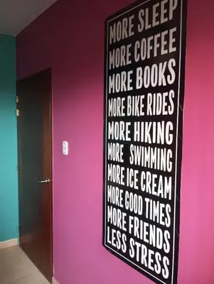 a black and white sign on a wall next to a pink wall at Casita de Playa in Barranca