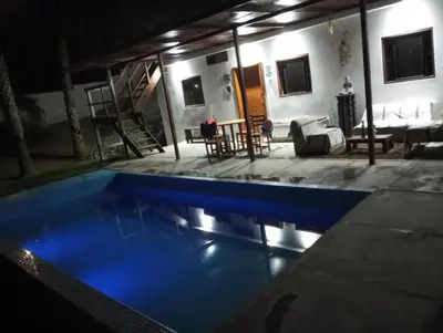a swimming pool at night with a living room at Casita de Playa in Barranca
