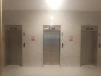 two elevators in a building with signs on the wall at Departamento en el edificio más alto del Perú, a 10 min de Plaza de Armas in Lima