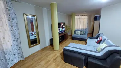 a living room with a blue couch and a television at Carosvi Home in Lima