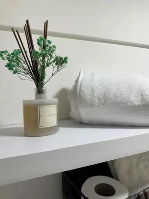 a vase with flowers on a shelf next to a pillow at 1Br AC San Isidro Apartment in Lima