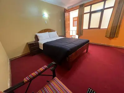 a bedroom with a bed and a large window at HOSTAL HUAYNA HOUSE GO in Cusco