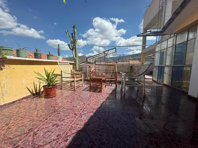 a patio with a table and chairs on a building at HOSTAL HUAYNA HOUSE GO in Cusco