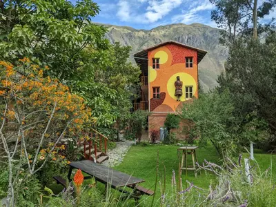 a house with a painting on the side of it at Full Moon Eco Lodge in Ollantaytambo