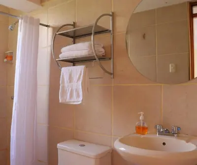 a bathroom with a toilet and a sink and a mirror at Full Moon Eco Lodge in Ollantaytambo