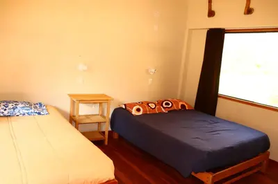 a bedroom with two beds and a window at Full Moon Eco Lodge in Ollantaytambo