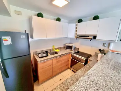 a kitchen with white cabinets and a refrigerator at DuplexTOP Miraflores Queen SmartTV Lima 1B 101 in Lima