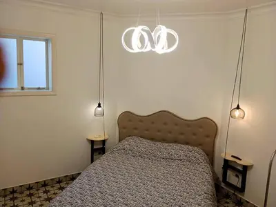 a bedroom with a bed with two lights on the wall at Departamento boutique in Lima