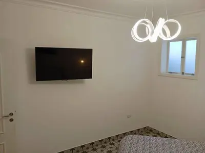 a living room with a tv on a white wall at Departamento boutique in Lima