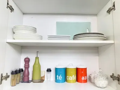 a shelf with plates and bowls and other items at Departamento con vista de Lima in Lima