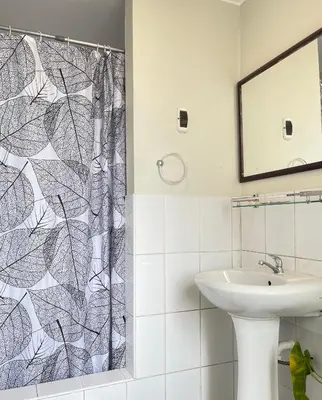 a bathroom with a shower curtain and a sink at Departamento con vista de Lima in Lima