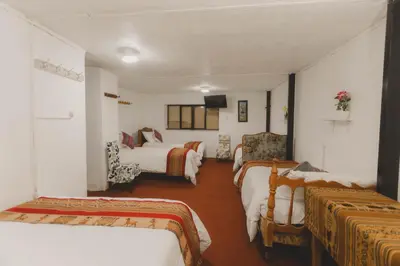 a hotel room with two beds and a tv at Lucios Cusco in Cusco
