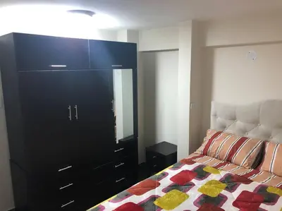 a bedroom with a bed and a dresser with a mirror at Mini Apartamento, cerca al Malecón de Chorrillos in Lima