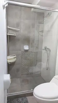 a bathroom with a glass shower with a toilet at Apartamento Varela 3 dormitorios in Lima