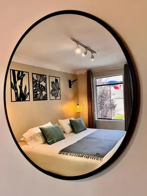 a bedroom with a bed with a round mirror at Casa Pardo in Cusco