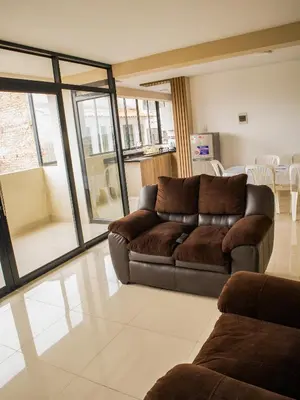 a living room with a brown couch and a table at Resort Maldo in Ayacucho