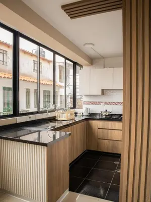 a kitchen with wooden cabinets and a large window at Resort Maldo in Ayacucho