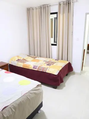 two beds sitting in a room with curtains at Resort Maldo in Ayacucho