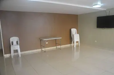 two chairs and a table in a room with a tv at Super céntrico y Hermoso Muy cerca a INEN in Lima
