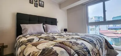 a bedroom with a large bed with a large window at Departamento de Estreno en Miraflores in Lima