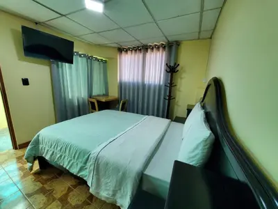 a bedroom with a bed and a flat screen tv at Jebas House in Cusco