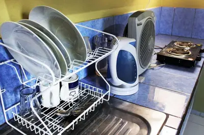 a drying rack with dishes and a toaster on a kitchen counter at Departamento Completo en San Luis - Complete Apartment in San Luis in Lima
