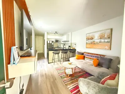 a living room with a couch and a kitchen at Vacation Escape - Elegant Barranco Stay near Beach & Art in Lima