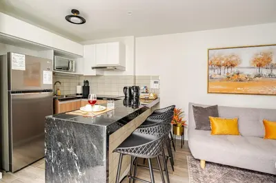 a kitchen and living room with a bar and a couch at Vacation Escape - Elegant Barranco Stay near Beach & Art in Lima
