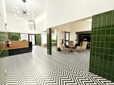 a bathroom with green and white tiled flooring at Vacation Escape - Elegant Barranco Stay near Beach & Art in Lima