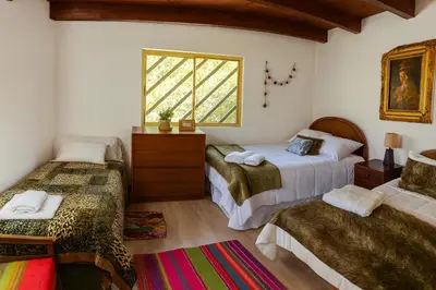 a bedroom with two beds and a window at La Casita de Orfi in Calca