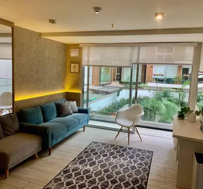 a living room with a blue couch and a chair at Great view and Pool apartment in Lima