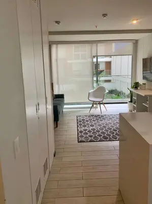 a kitchen with a table and a chair in a room at Great view and Pool apartment in Lima