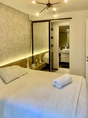 a bedroom with a large white bed with a mirror at Great view and Pool apartment in Lima