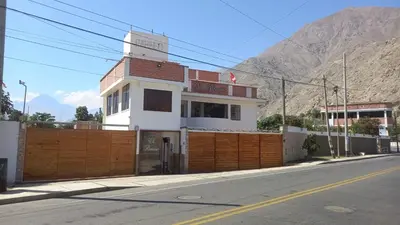 a building on the side of a street with a fence at El Paraíso de Lunahuaná in Lunahuaná