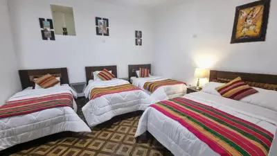 a group of four beds in a room at Mallku Wasi - Lodging Hotel Cusco in Cusco