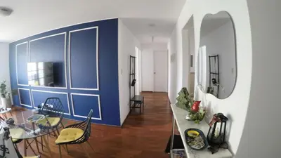 a living room with a blue wall and a table and chairs at Excelente ubicación, vista al mar, cerca a Costa 21 in Lima