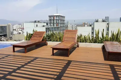 three wooden benches sitting on top of a building at Hermoso departamento con piscina, gimnasio, sala parrillas in Lima