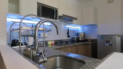 a kitchen with a stainless steel sink and a microwave at Hermoso apartamento en San Isidro in Lima