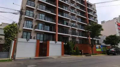 an apartment building with two garage doors on a street at Hermoso apartamento en San Isidro in Lima