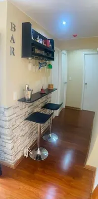 a living room with a fireplace and two bar stools at Sai in Lima