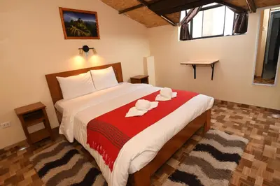 a bedroom with a large bed with a red blanket at Casa Medina Hostal in Cusco