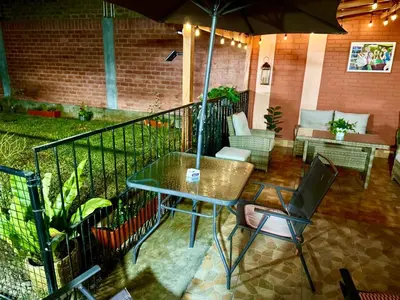a patio with a table and chairs and an umbrella at Bello depa San Miguel 3 camas 2 tv smart terraza in Lima