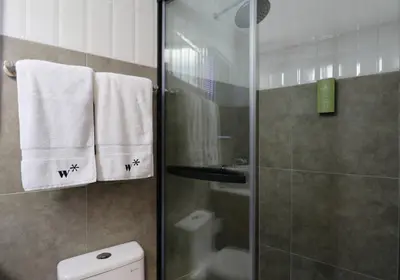 a bathroom with a shower and a toilet and towels at Dasso 167 by Wynwood House in Lima
