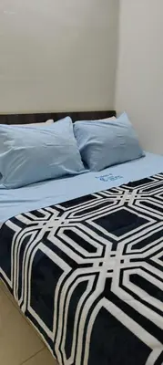 a bed with a black and white blanket on it at Hospedaje CASA REAL in Huancayo