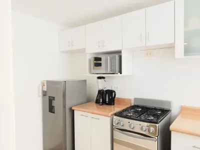 a kitchen with white cabinets and a stainless steel refrigerator at Centro Histórico de Lima, Departamentos Temporales in Lima