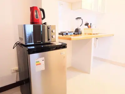 a microwave on top of a refrigerator in a kitchen at Departamentos Céntricos en Lima in Lima