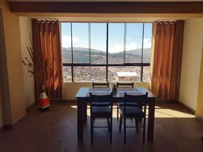 a dining room with a table and chairs and a large window at Hathun House in Cusco