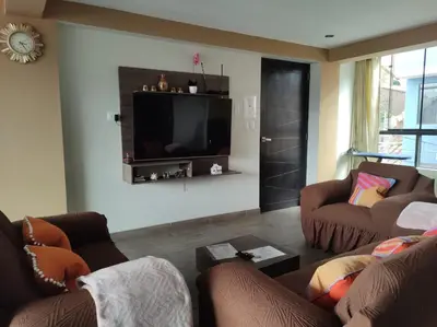 a living room with two couches and a flat screen tv at Hathun House in Cusco