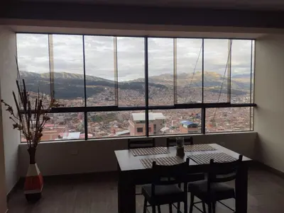 a dining room with a table and chairs and a large window at Hathun House in Cusco