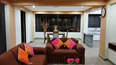 a living room with a brown couch with colorful pillows at Hathun House in Cusco